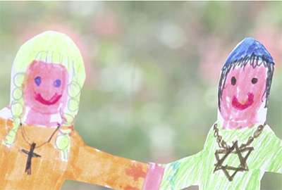 Zwei gemalte Kinderfiguren mit religiösen Symbolen halten sich an den Händen