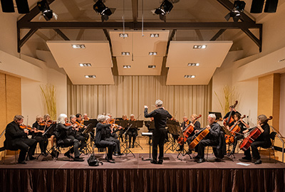 Orchester Collegium Musicum während eines Konzerts, Dirigent vor den Musikern